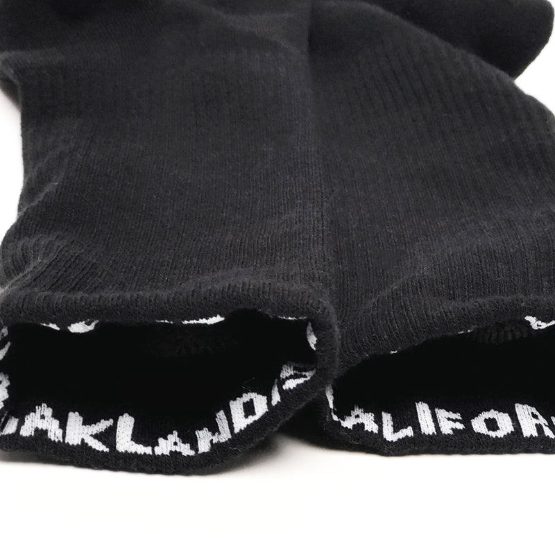 Close-up of the top of crew socks insides to expose the Oaklandish & California wordmarks - one on each of the rims. 