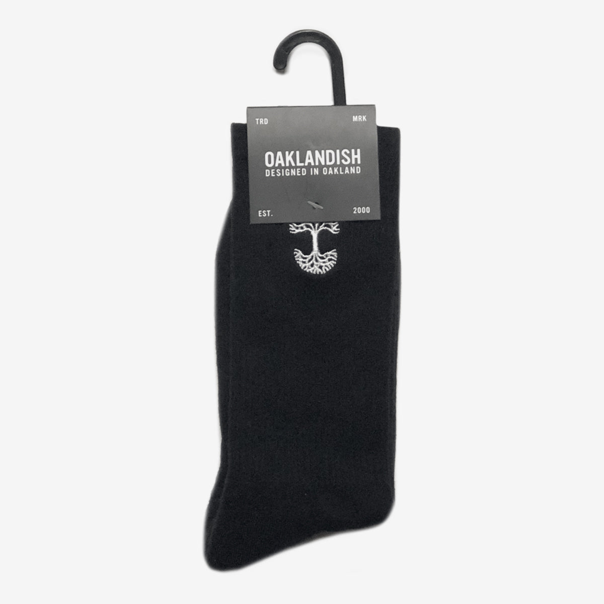 High-cut men's black crew socks with white embroidered Oaklandish logo at the top wrapped in Oaklandish retail packaging.