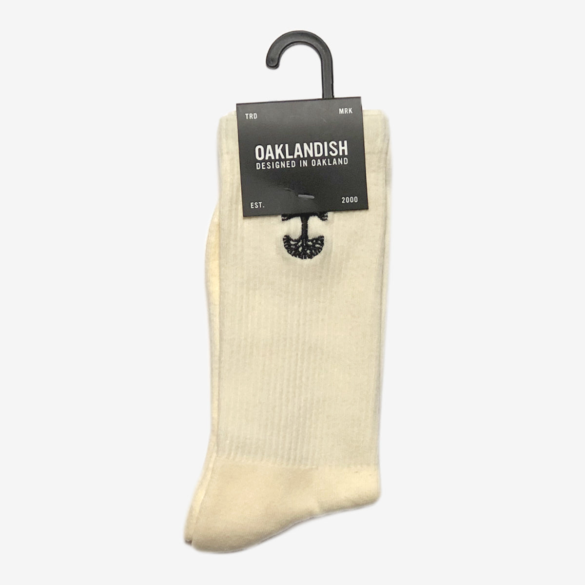 High-cut men's cream crew socks with black embroidered Oaklandish logo at the top wrapped in Oaklandish retail packaging.