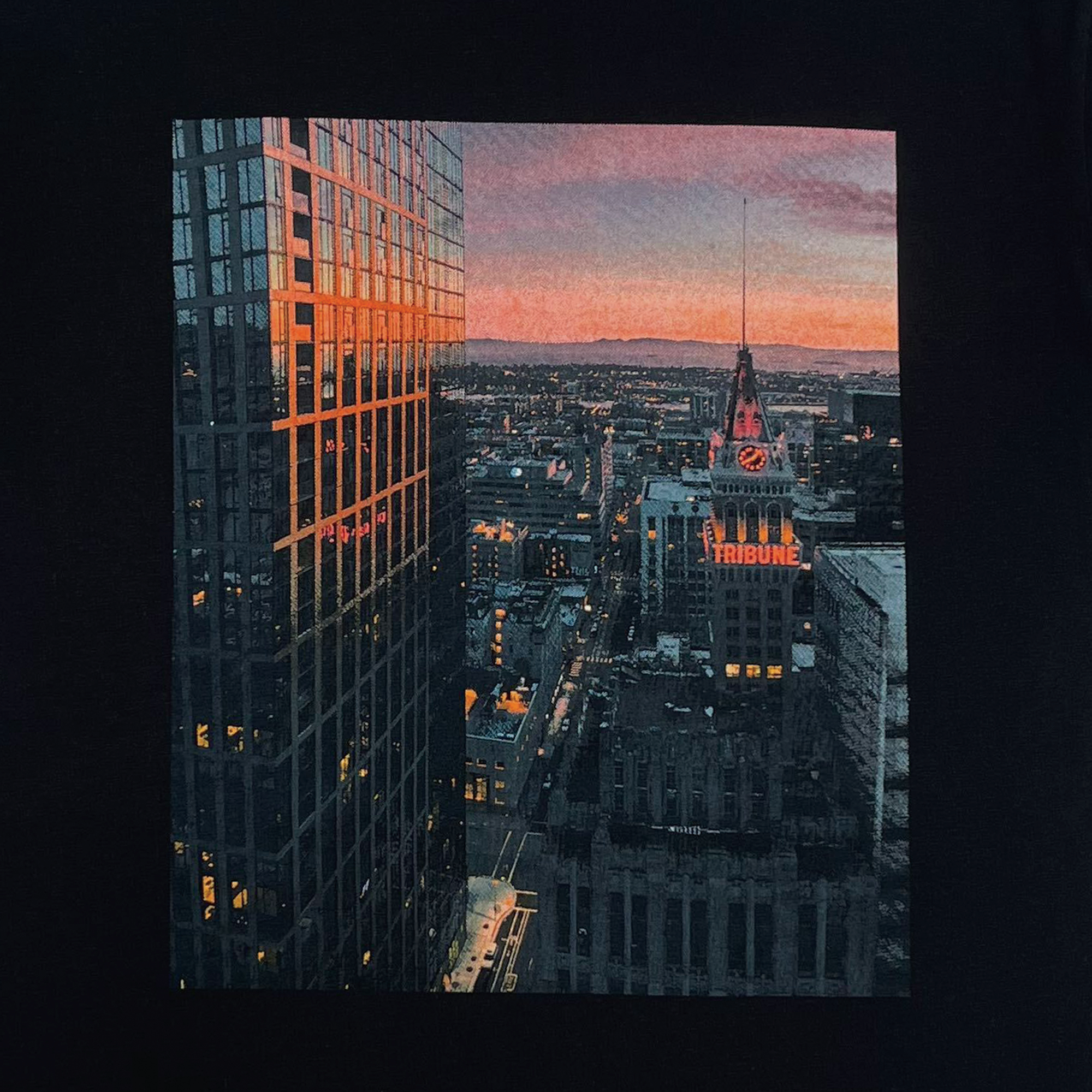 Close-up of Vincent James' photography image of the Oakland Tribune building and the Downtown Oakland landscape on a black t-shirt.