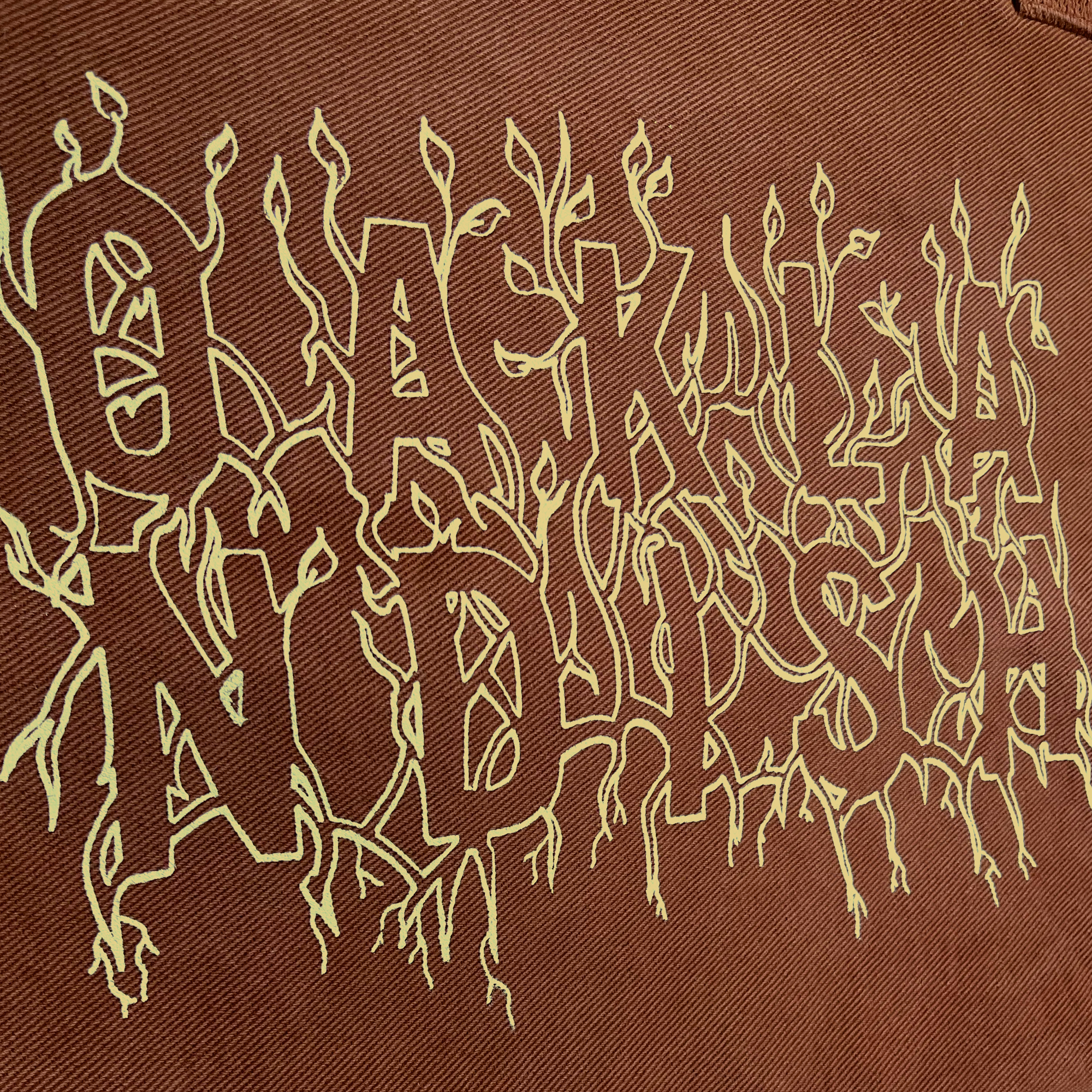 Close-up of creme ink and Oaklandish wordmark surrounded by stems and vines on Ginger tote bag.