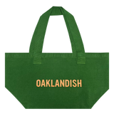 Front view of vintage green shopping tote with Oaklandish wordmark in creme ink creme ink.
