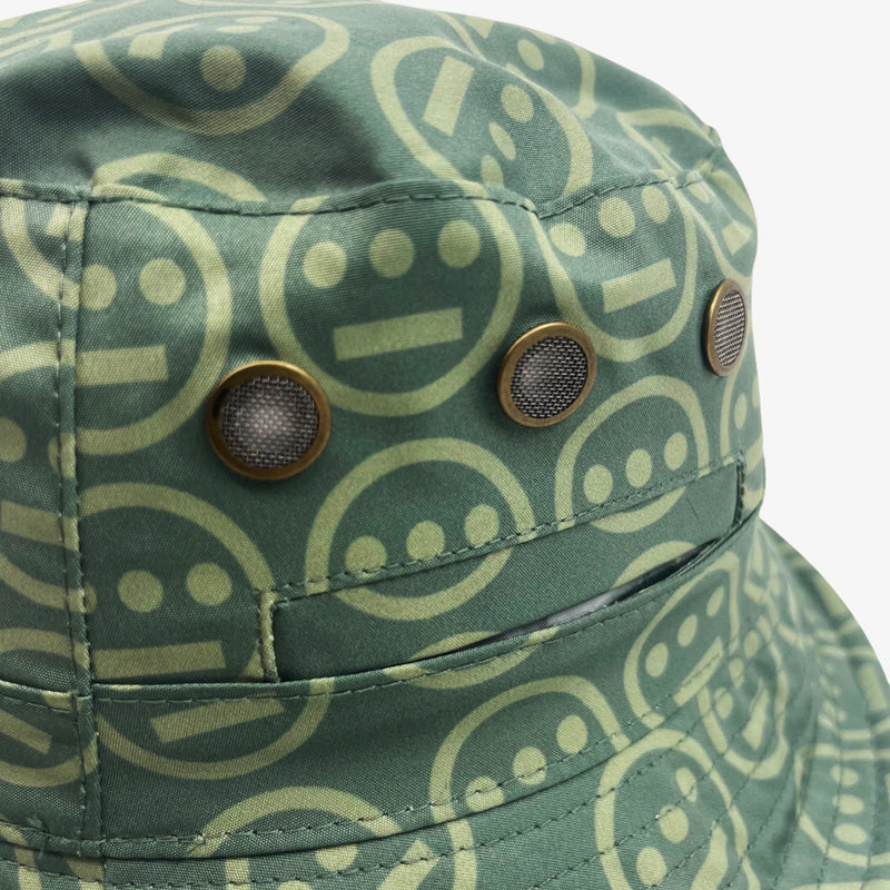 Close-up of vents on the green side of a reversible bucket hat with light green Hieroglyphics hip-hop logo on repeat. 