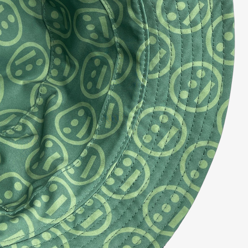 Close-up of underside of the rim on the green side of a reversible bucket hat with light green Hieroglyphics logo on repeat. 
