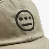 Close up of black embroidered Hiero hip-hop crew logo on crown of a khaki dad cap.