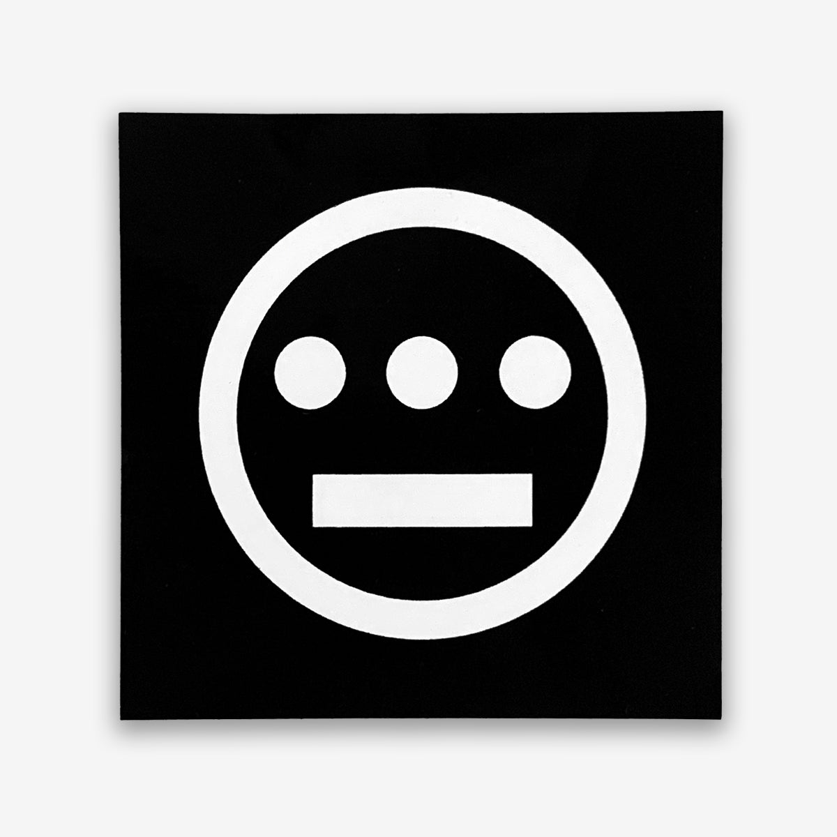The Hiero Logo Sticker by Hieroglyphics features a black square with a minimalist design: a white circular symbol at the center. Inside the circle, three small white dots are aligned horizontally near the top, with a thick white horizontal line beneath them, creating an iconic face-like image. This sticker is perfect for representing your hip-hop crew on any surface.