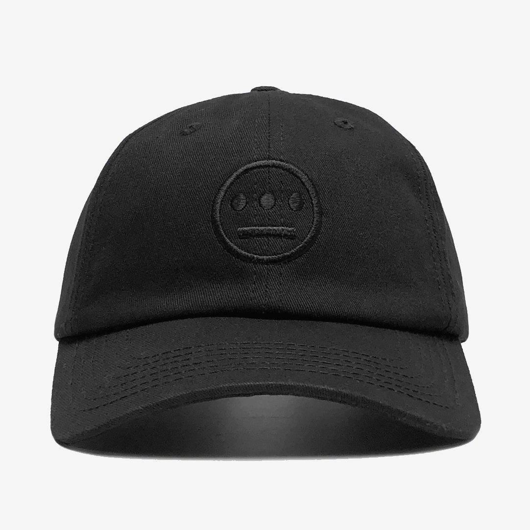 The Hiero Logo Dad Hat by Hieroglyphics features a black design with an embroidered logo on the front, depicting a minimalist face with two eyes and a straight line as a mouth encircled by a ring, reminiscent of hieroglyphics. It has a curved brim, visible stitching on the panels, and an adjustable strapback against a white background.