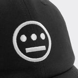 Close up of white embroidered Hiero hip-hop crew logo on crown of a black dad cap.