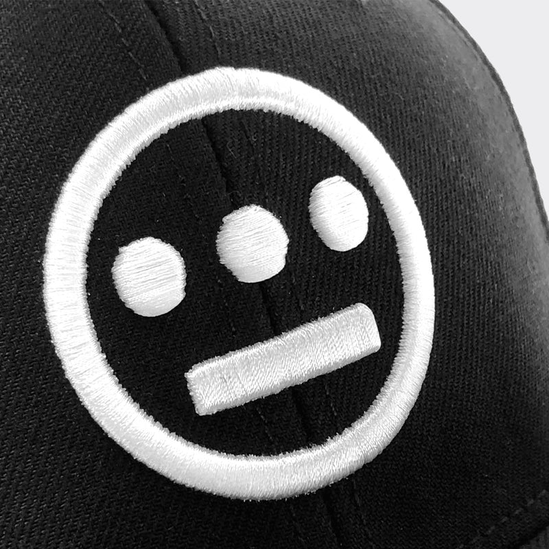Close-up of embroidered white Hieroglyphics logo on a black cap.