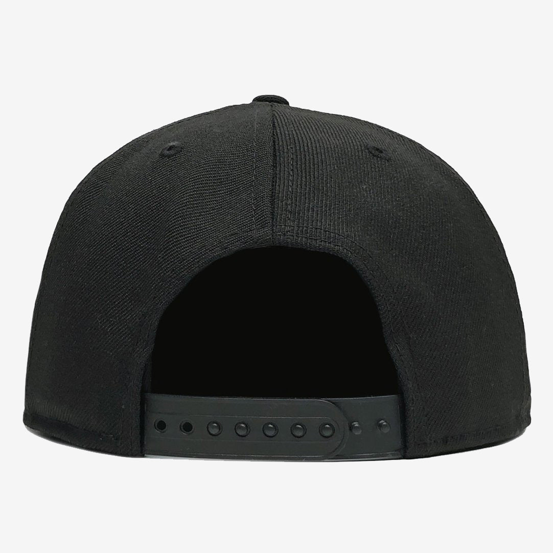 The image shows the rear view of a black Hiero Logo Snapback by Hieroglyphics, epitomizing modern headwear. The cap features a fabric crown with visible stitching lines and an adjustable plastic snapback closure. The intricately designed snapback strap, reminiscent of ancient hieroglyphics, has several small holes for size adjustment. The background is plain white.