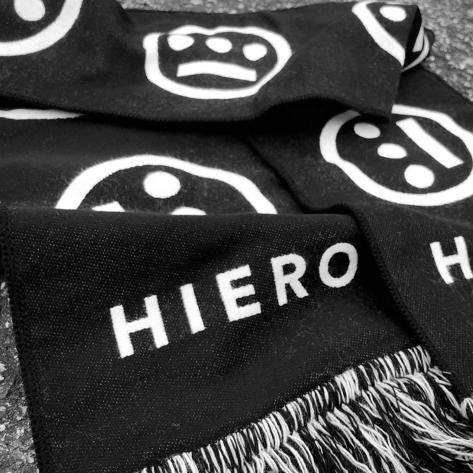 Detailed close-up of HIERO wordmark on a black woven scarf.