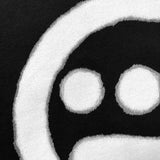 Close up of spray-painted Hieroglyphics hip-hop logo on the chest of a black t-shirt.