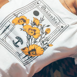 Detailed close-up of a woman wearing a natural color Oaklandish Blossom t-shirt.