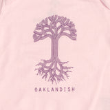 Close-up of the purple Oaklandish tree logo and wordmark on the chest of a pink infant one-piece