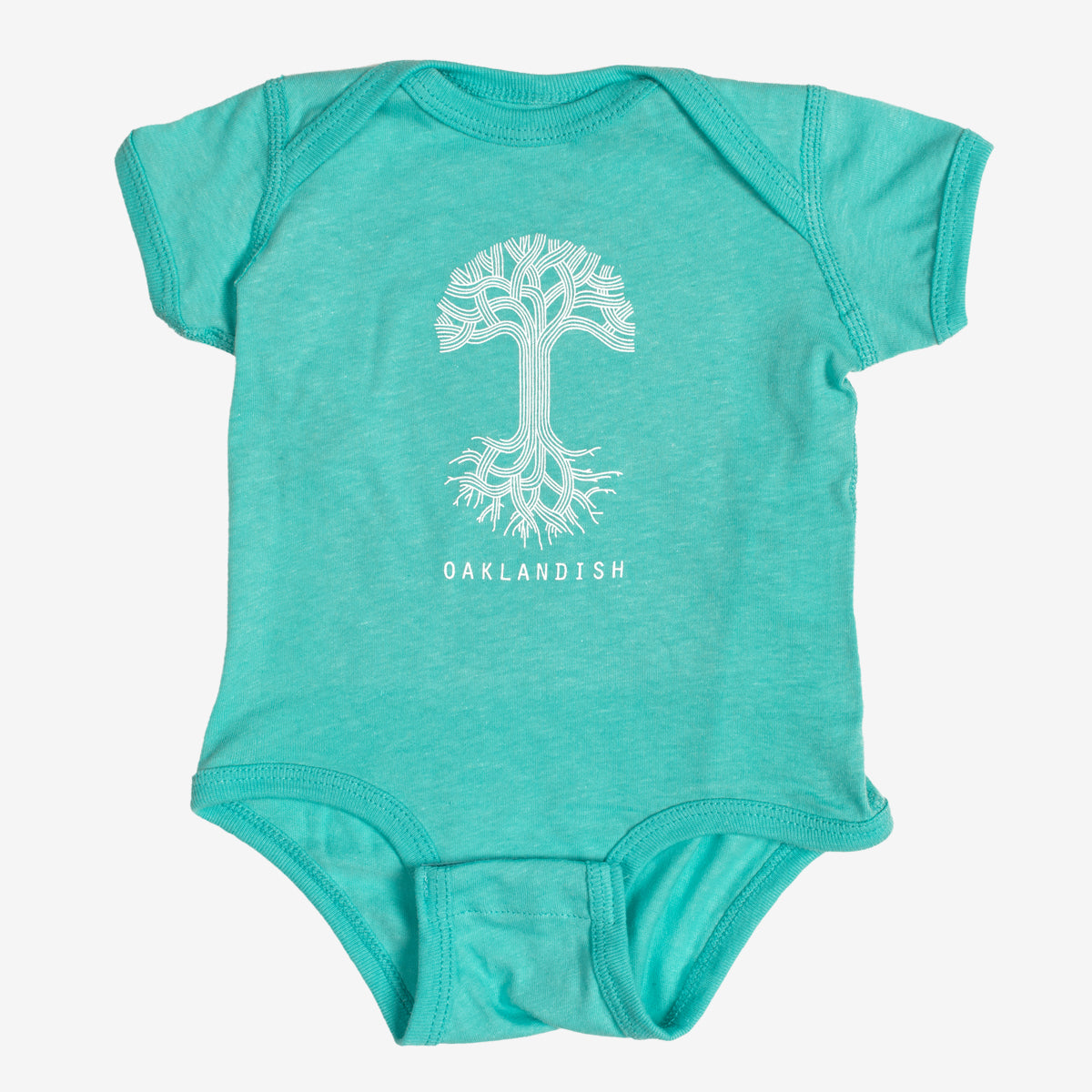 The Infant Oaklandish Classic Logo One-Piece by Oaklandish is a teal, 100% cotton short-sleeve romper featuring a round neckline and snap closures at the bottom. It showcases a white graphic of a tree with roots extending downward, with "OAKLANDISH" printed in white capital letters below the tree.