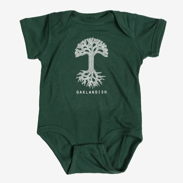 Forest green infant one-piece with a white Oaklandish tree logo and wordmark on the chest.