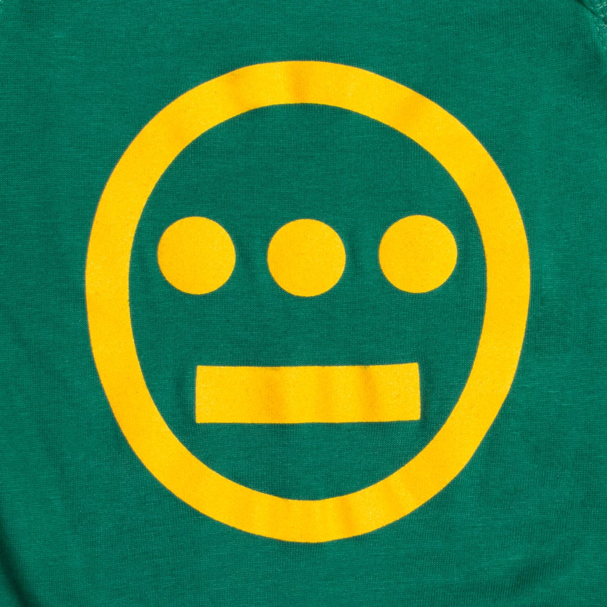Close-up of large yellow Hiero hip-hop crew logo on a green infant one-piece.