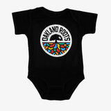 Black infant one-piece with full-color Roots SC mosaic logo and wordmark on the chest.