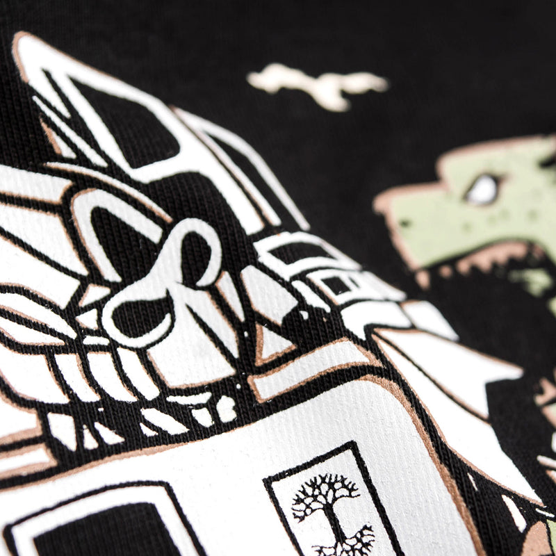 Detailed close-up of graphic of Kaiju vs. Autobart monsters invading Oakland on a black t-shirt laying on asphalt. 