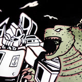 Detailed close-up of graphic of Kaiju vs. Autobart monsters invading Oakland on a black t-shirt laying on asphalt. 