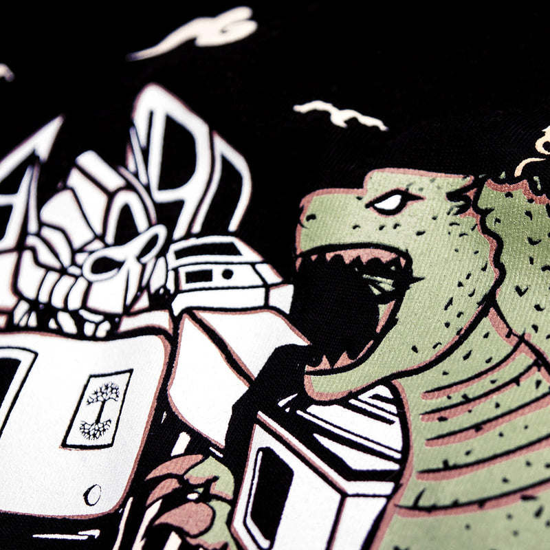 Detailed close-up of graphic of Kaiju vs. Autobart monsters invading Oakland on a black t-shirt laying on asphalt. 
