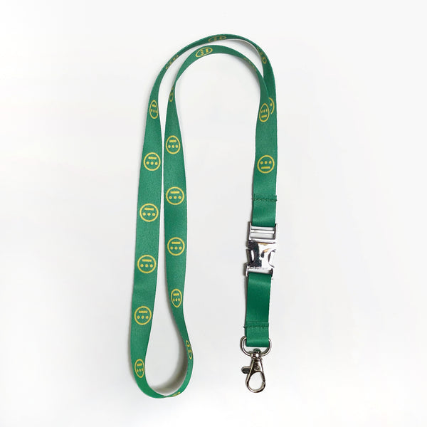 Close up of green quick release lanyard with yellow Hieroglyphics logo on repeat. 