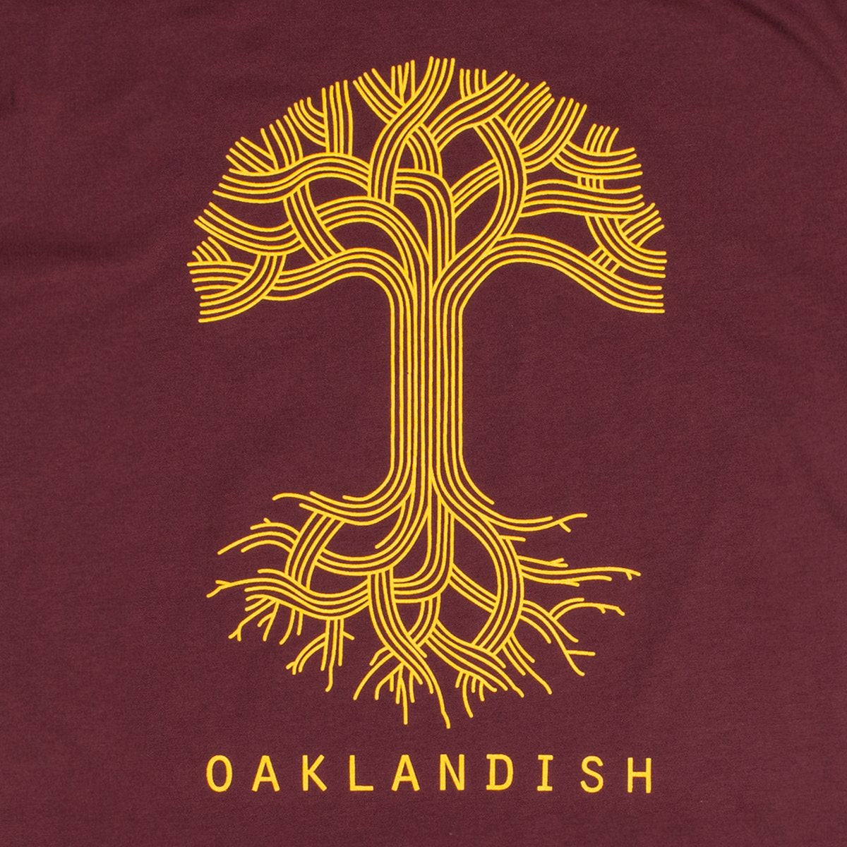 Close-up of a large yellow Oaklandish tree logo on the chest of a burgundy t-shirt.