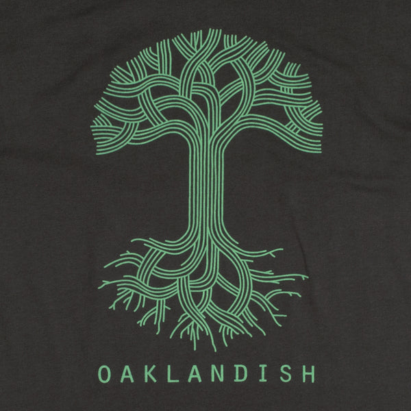 Close-up of a large green Oaklandish tree logo and wordmark on the chest of a coal-black t-shirt.