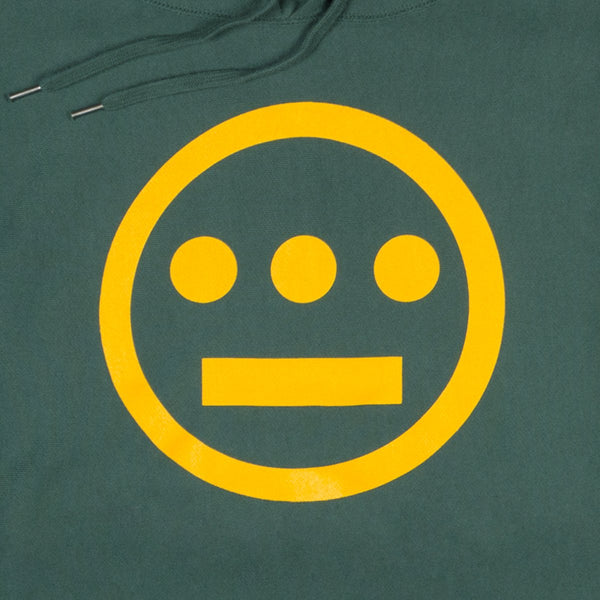Close-up of yellow Hieroglyphics hip hop logo on the chest of a green hoodie.