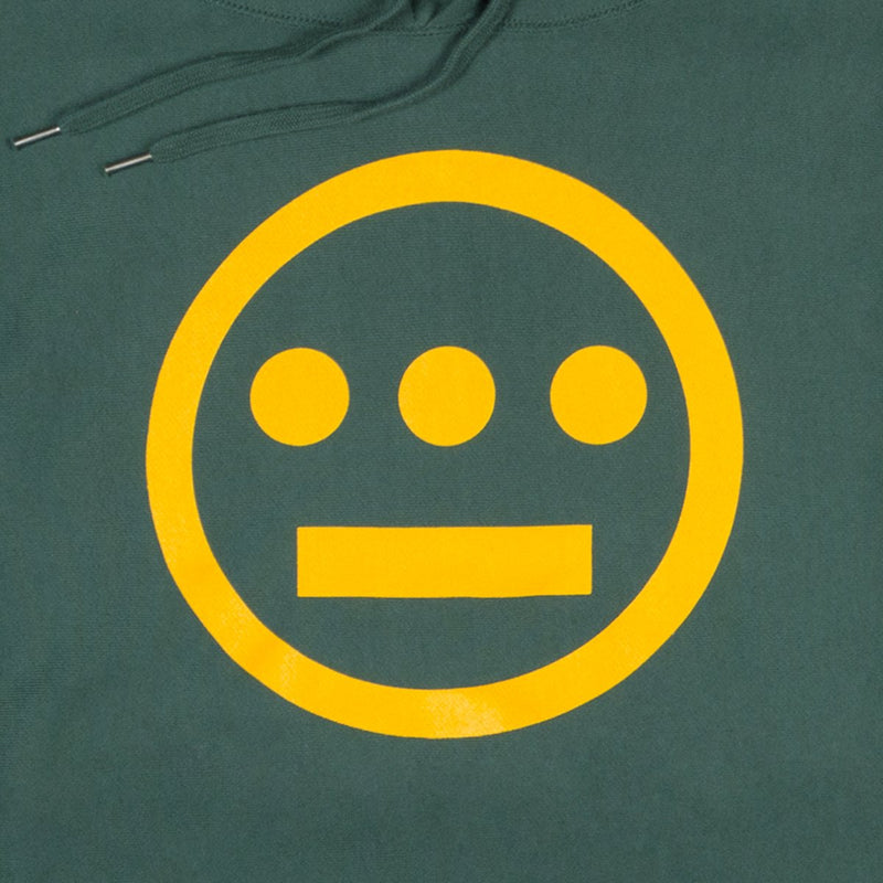 Close-up of yellow Hieroglyphics hip hop logo on the chest of a green hoodie.