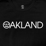 Close-up of OAKLAND wordmark with Hieroglyphics hip-hop crew logo as the O on a black t-shirt. 