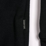 Close-up of OAKLANDISH tag on the side of a black crewneck sweatshirt.