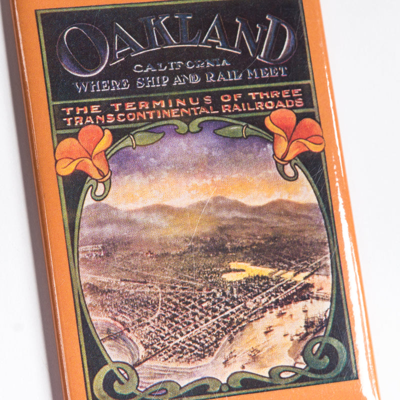 Close up of fridge magnet with an antique image of Oakland with words “Oakland California Where Ship & Rail Meet.”
