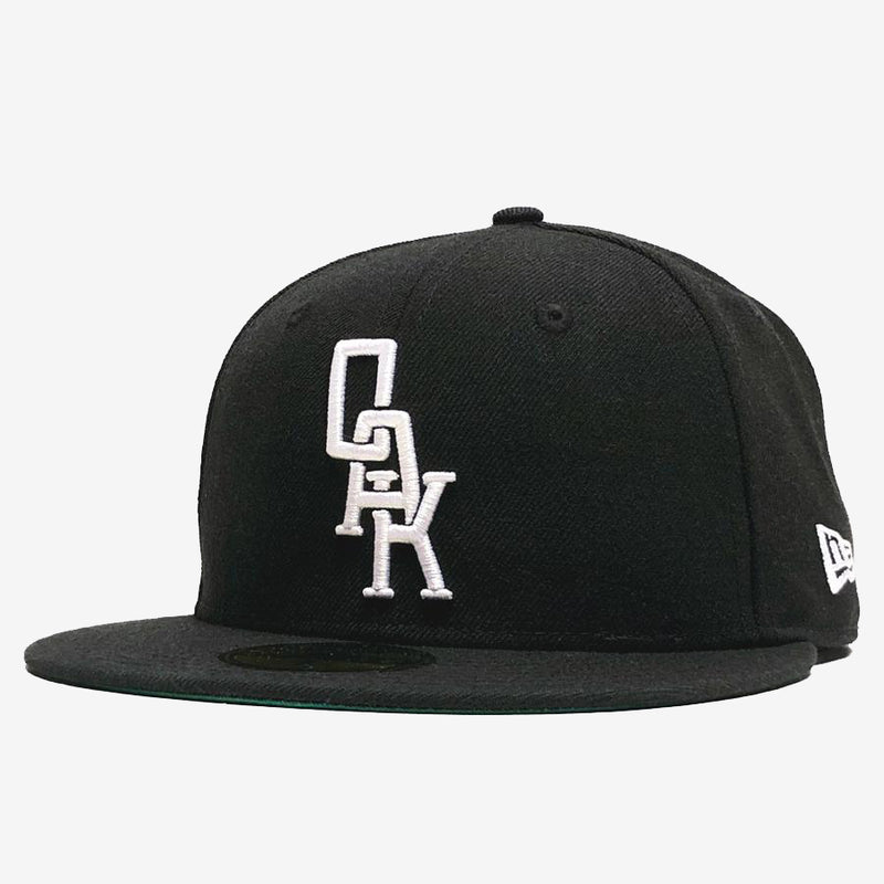 Black New Era cap with white embroidered OAK wordmark on the crown.