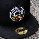 Close-up of embroidered full-color circle Roots SC mosaic logo on a black New Era cap.