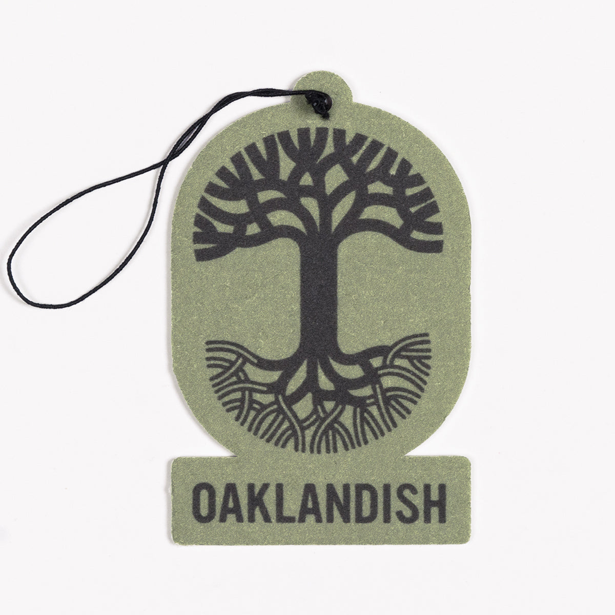 The Oaklandish Air Freshener, from the renowned brand Oaklandish, is a green air freshener featuring a black string at the top for hanging. It showcases a black, stylized tree with spreading roots and branches in the center, enclosed within an oval shape. Beneath the image is "OAKLANDISH" displayed in bold black letters. This air freshener is ideal for those who appreciate unique accessories and delightful scents.