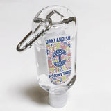 Close-up of travel-size hand sanitizer with Oaklandish logo and carabiner.