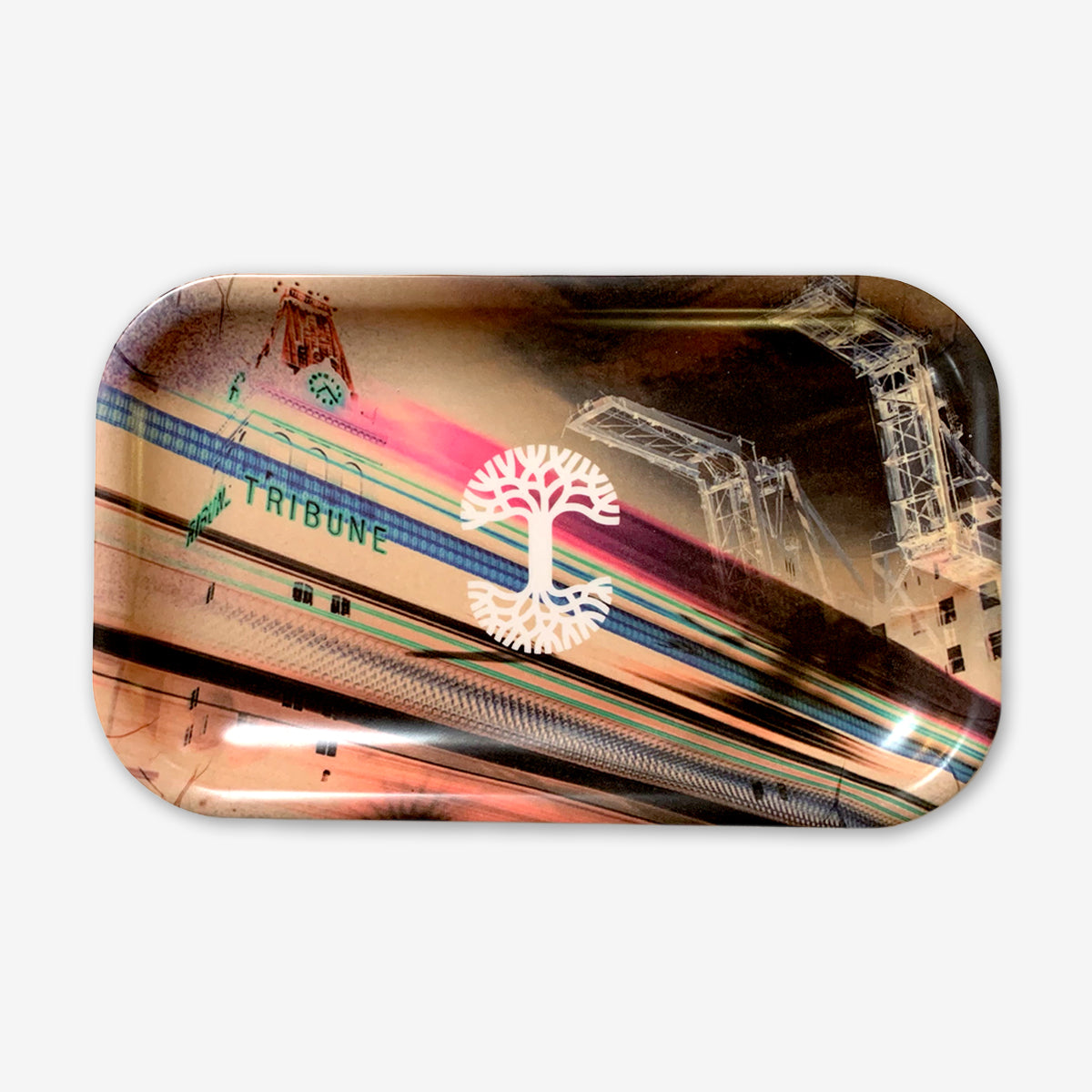 The Neon High rectangular multi-purpose tray by Oaklandish showcases an abstract collage design. Prominent elements include a clock tower with the word "TRIBUNE" and large cranes. Centered on the melamine composite tray is a white, stylized tree logo against a background of muted tones and radiating lines that suggest motion.