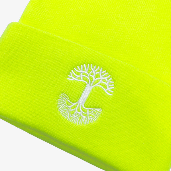 Close-up of white embroidered Oaklandish tree logo on the cuff of a fluorescent yellow beanie.