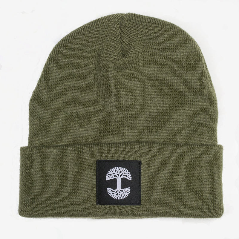 An olive green woven cuffed beanie with a black and white Oaklandish logo tag on the cuff