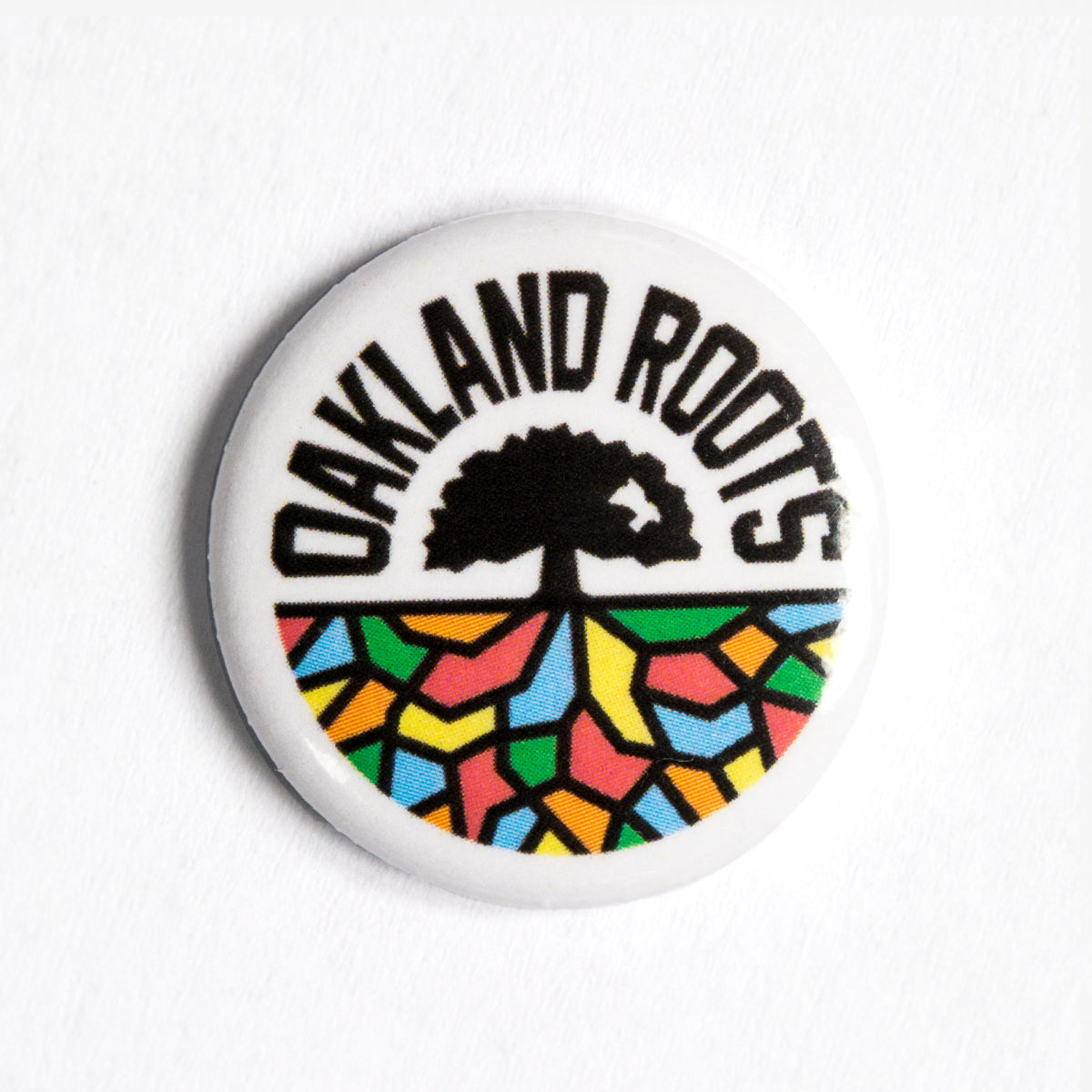 Oakland Roots full-color logo crest on a lapel pin.