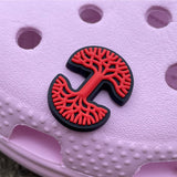 Red and black Oaklandish tree logo shoe charm on a pink croc shoe.