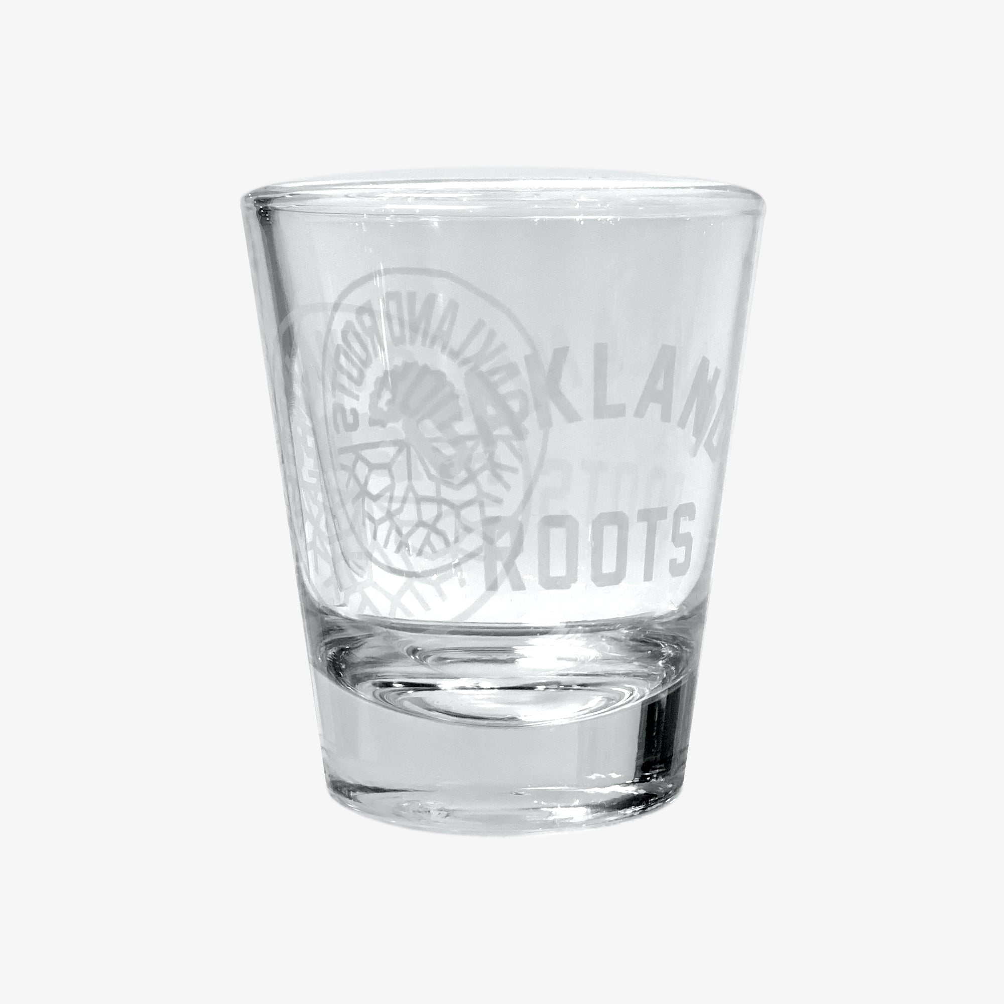 Liquor shot glass (1.75 oz) with translucent white Oakland Roots logo crest and OAKLAND ROOTS wordmark.