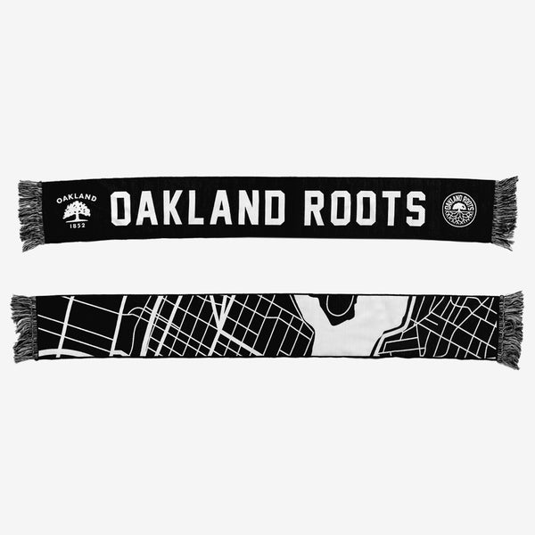 Black & white two-sided woven scarf with “OAKLAND ROOTS”  wordmark, circle logo, and Oakland 1852 Flag logo on one side and graphic map of Oakland on the other.