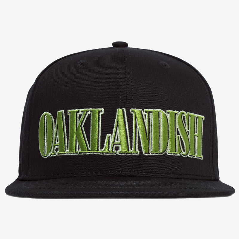 Black snapback cap with green embroidered Oaklandish tree logo on the front. 
