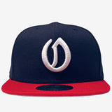 A navy New Era cap with a white embroidered A's O logo and a New Era sticker on the red bill.