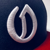 Close up of white embroidered A's O logo on the front of a navy cap.