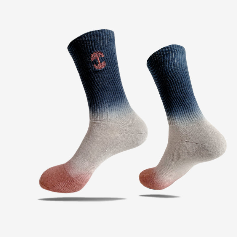 High-cut men's crew socks, dip-dyed navy, grey and pink with pink embroidered Oaklandish logo at the top.