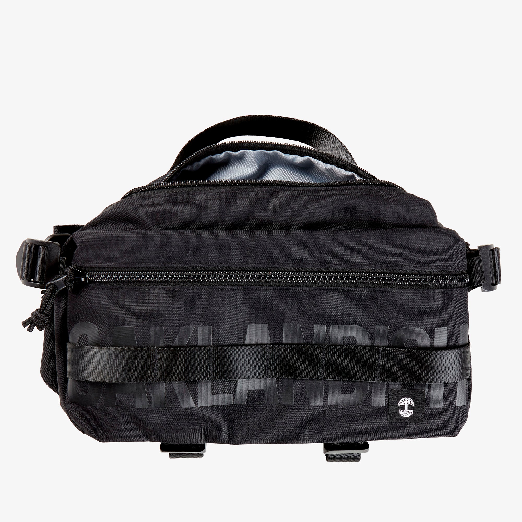 A black nylon hip bag with a black Oaklandish wordmark, with open top zipper, waist belt, & small white Oaklandish tree logo.