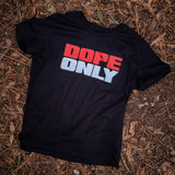 A close-up of a women's black t-shirt with a large red and white DOPE ONLY wordmark logo  on a forest floor.